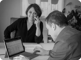 Rendez-vous entre un expert-comptable et sa cliente, échange autour d’un ordinateur portable