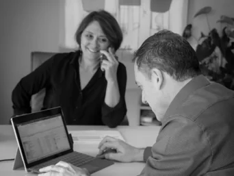 Rendez-vous entre un expert-comptable et sa cliente, échange autour d’un ordinateur portable